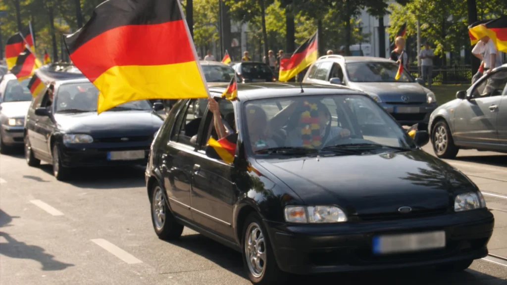 Deutsche Fußballfans feiern 2006 mit Deutschlandfahnen in einem Autokorso