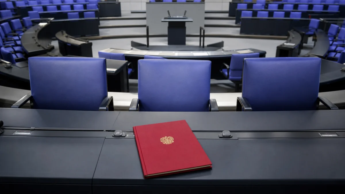 Drei leere Ministerstühle im Bundestag neben einer Ernennungsurkunde