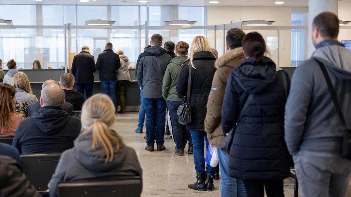 Wartende Menschen in einer Arbeitsagentur von hinten