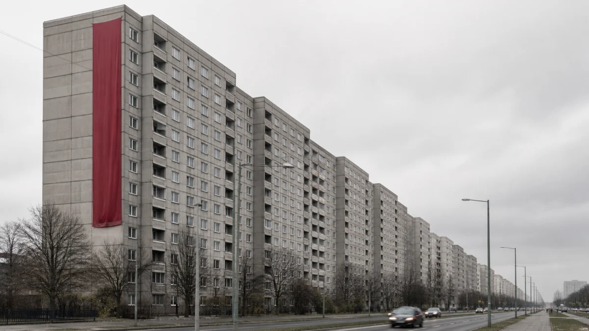 Graue Berliner Plattenbauten mit einem roten Banner