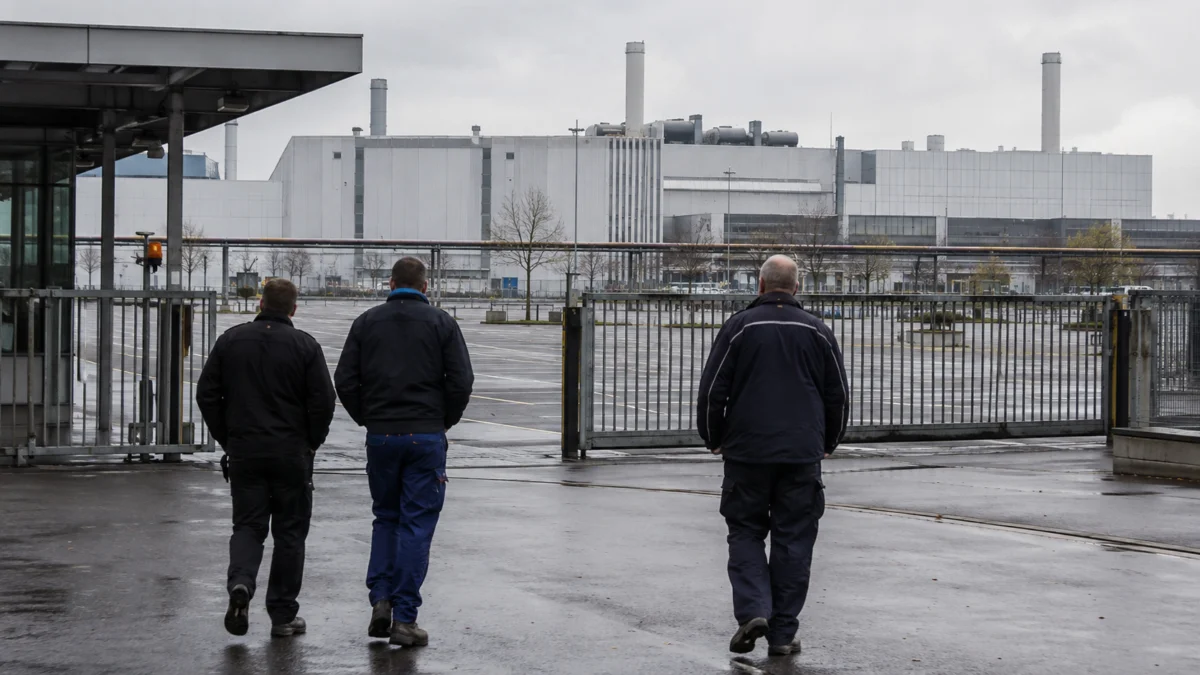 Drei Arbeiter vor einem deutschen Automobilwerk